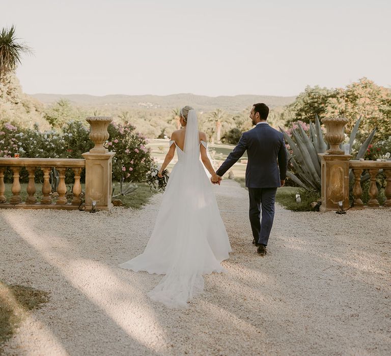 Bride & groom walk through grounds of Chateau de Robernier 