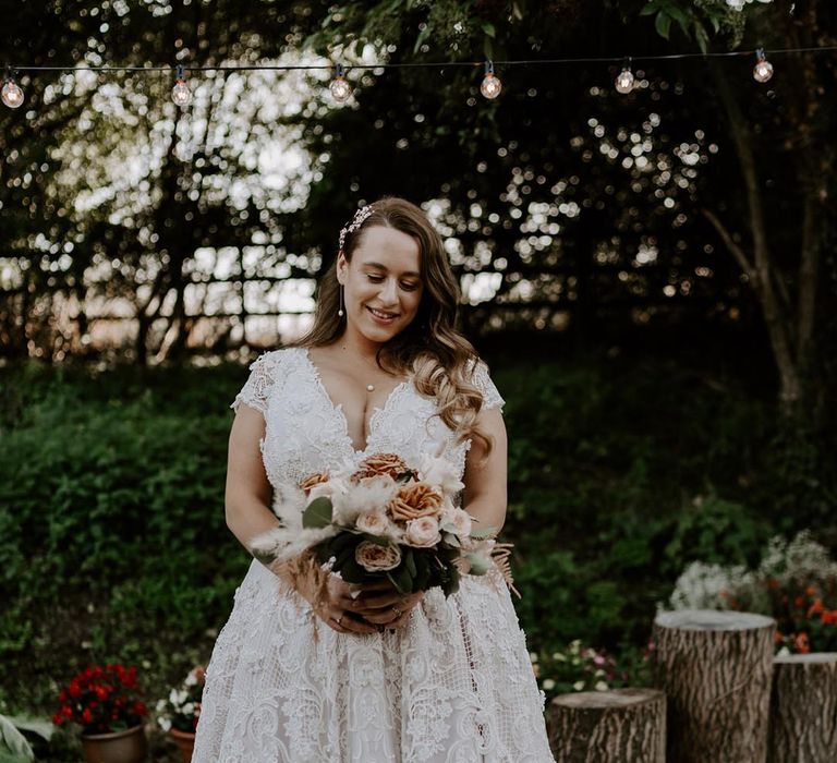 Bride in a short sleeve lace wedding dress for a DIY wedding 