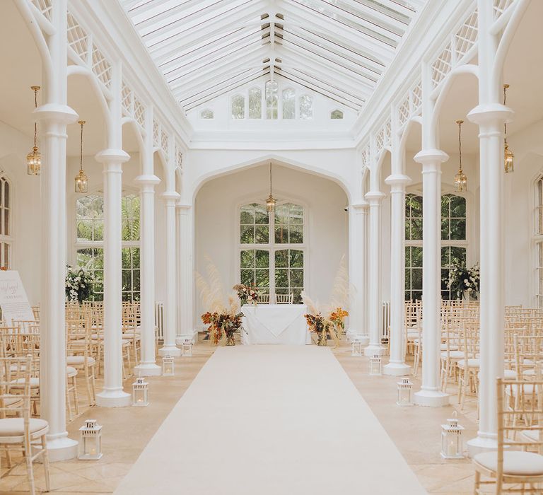 St Audries Park wedding venue complete with lanterns lining the aisle and pampas grass installations to the front of the aisle 