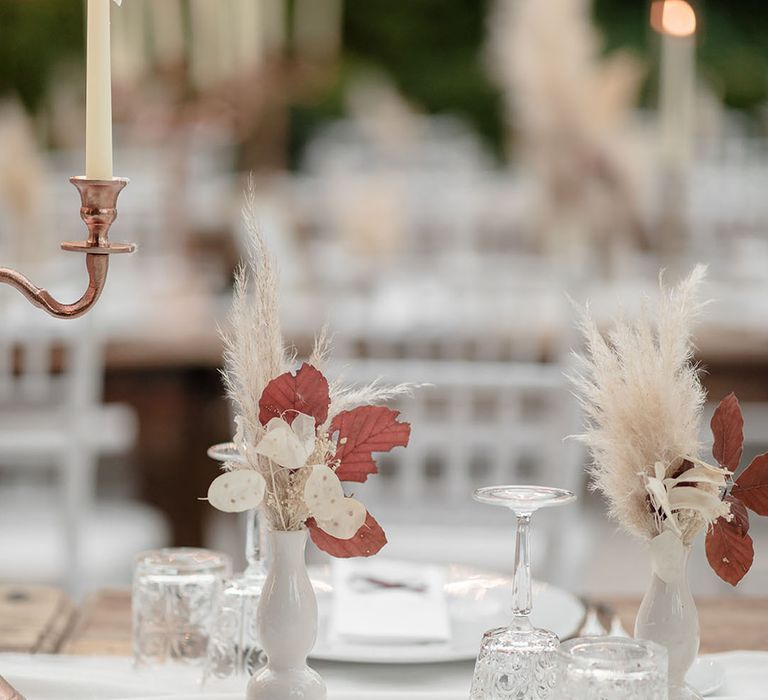 Small pampas grass arrangements in white vases 