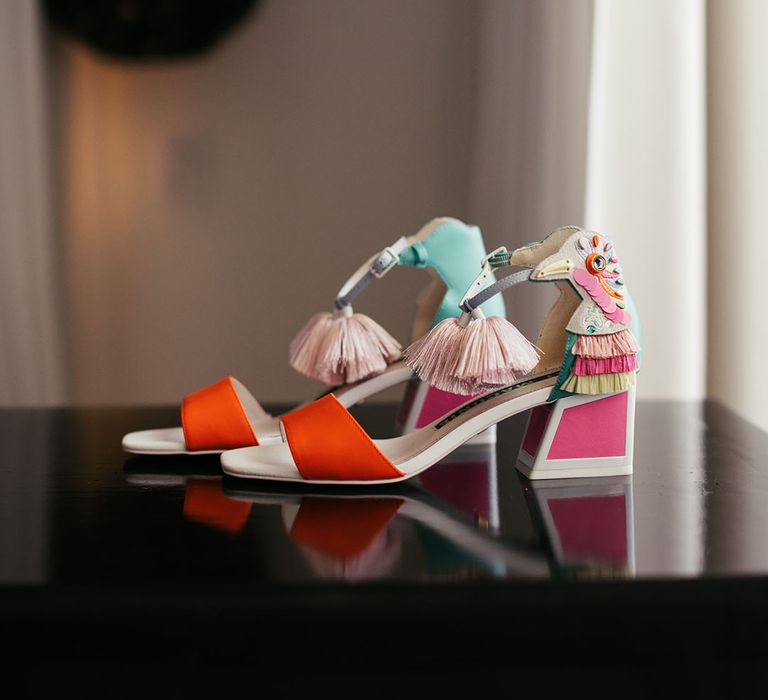 Colourful bridal wedding shoes complete with pink tassels and bright orange straps to the front 