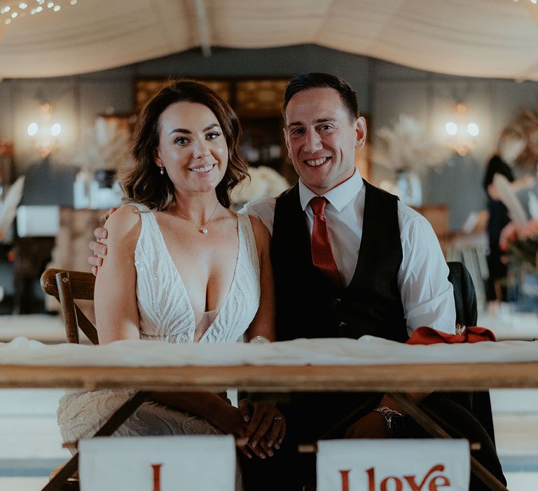 Custom made white and burnt orange wedding banners hanging from the top table for the bride and groom 