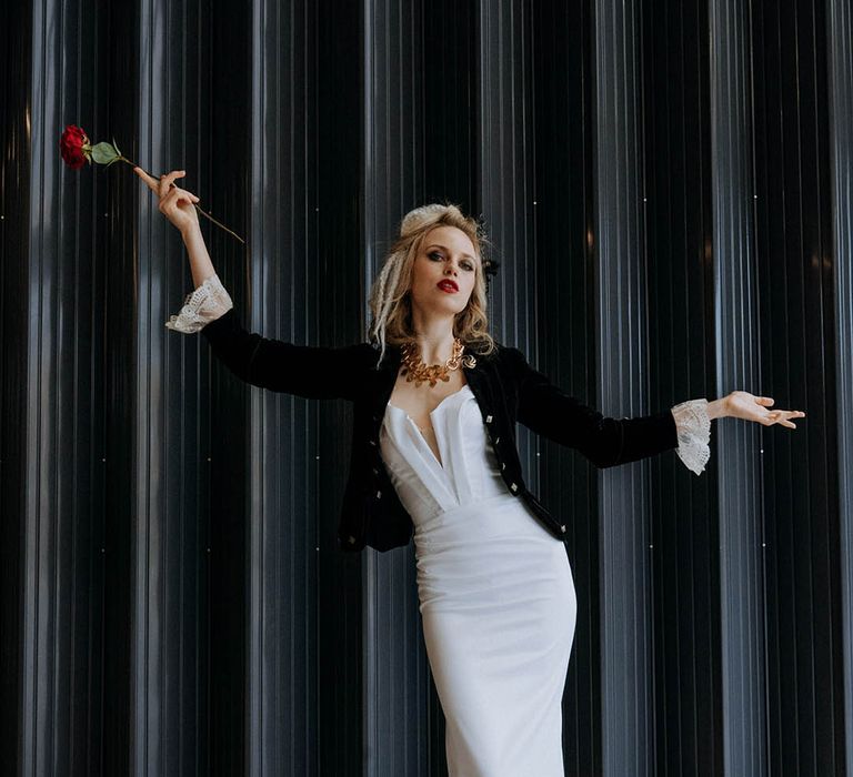 Bride in sculpted bandeau maxi wedding dress with black lace detailing on the train and black fitted jacket with cream lace sleeves