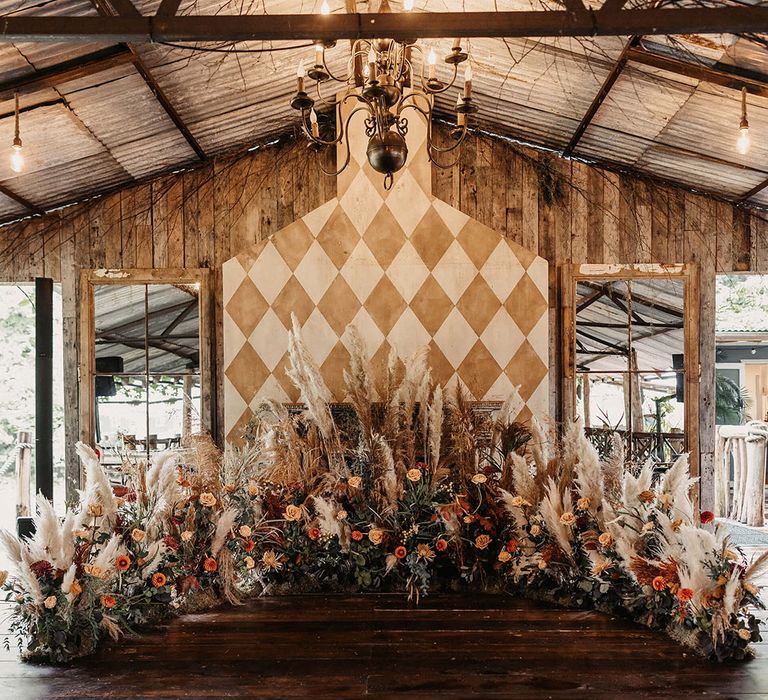 Dried floral Autumnal arrangement with pampas grass to the front of aisle 