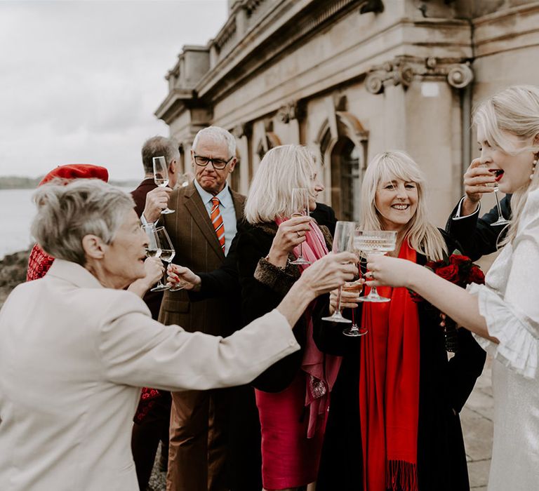 The bride shares a toast with her wedding guests and drink champagne together to celebrate the day