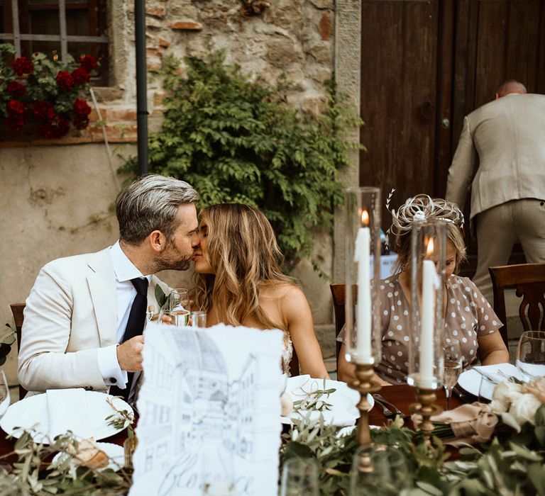 Bride and groom share a kiss during the wedding breakfast at destination wedding