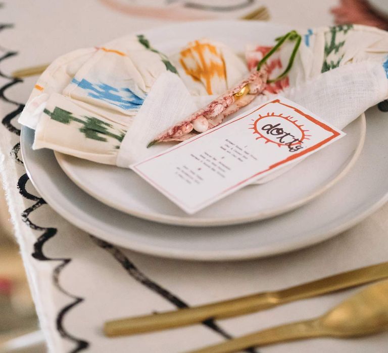 Artsy abstract wedding napkin and alternative wedding decor on abstract wedding tablecloth with gold cutlery, off-white plates and abstract wedding stationery