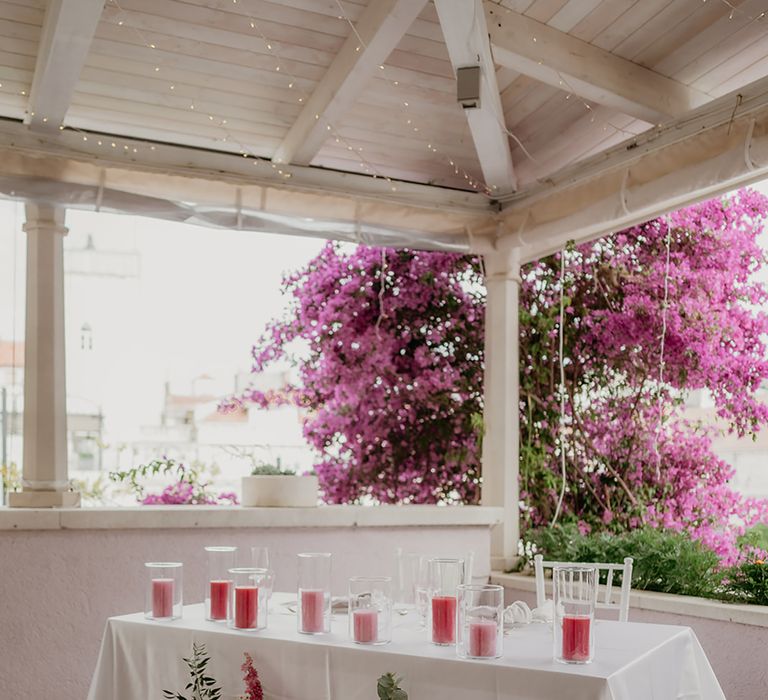 Sweetheart table at Restaurant Park Hvar wedding breakfast with pink and blush candle decor and a flower arrangement featuring blush peonies, pink chinese peonies and roses