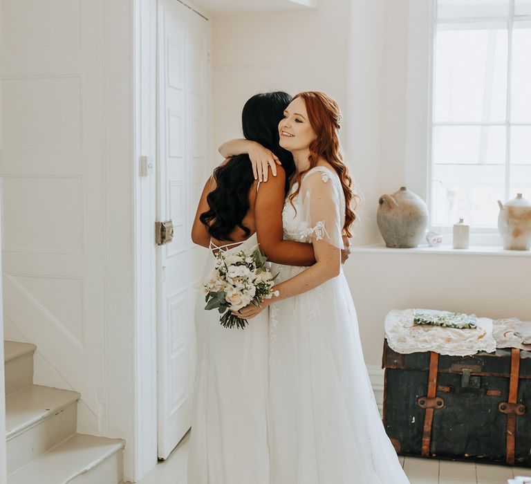 Romantic first look moment between two brides at barn wedding 