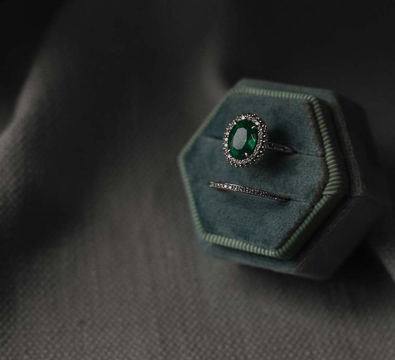 Green ring box featuring an emerald oval engagement ring and wedding band chosen to fit the bride perfectly 