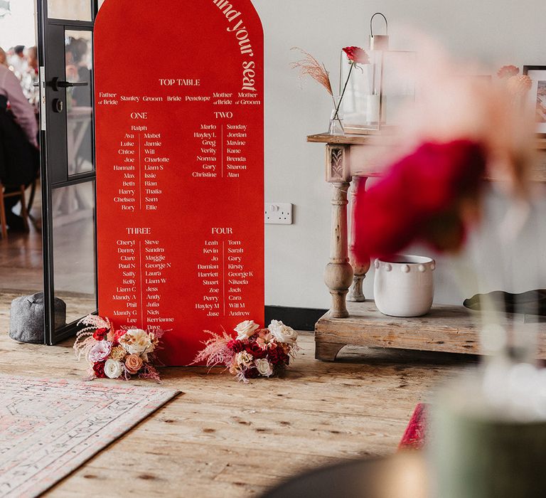 Red and white tall wedding table plan signage at red and pink theme wedding day 