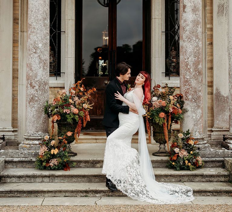 Bride in off the shoulder lace wedding dress with groom at their country house wedding 