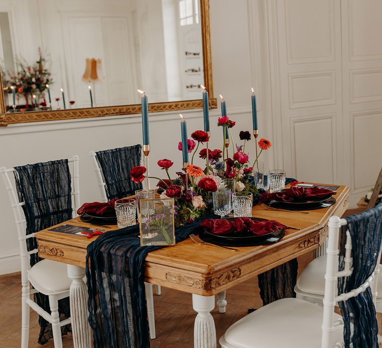 Navy sheer table runner and chair decorations with red wedding flowers 