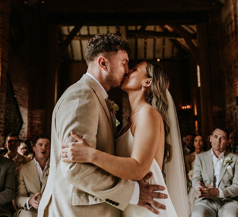 The bride and groom share their first kiss as a married couple 