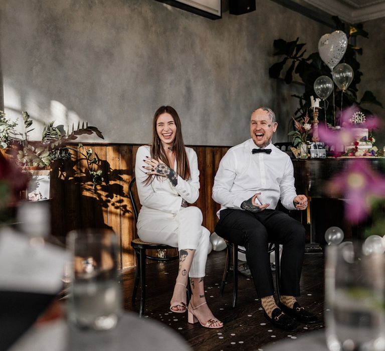 Bride and groom laughing during pub wedding reception 