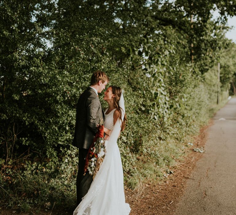 bride and groom portrait by Heather Sham in a country lane 