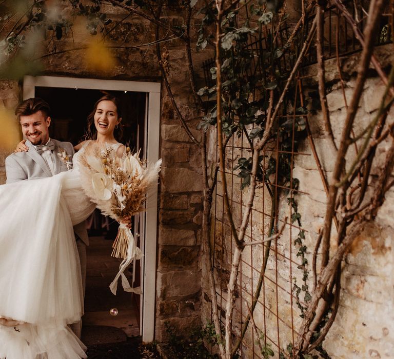 Bride and Groom just married with dried flower wedding bouquet 