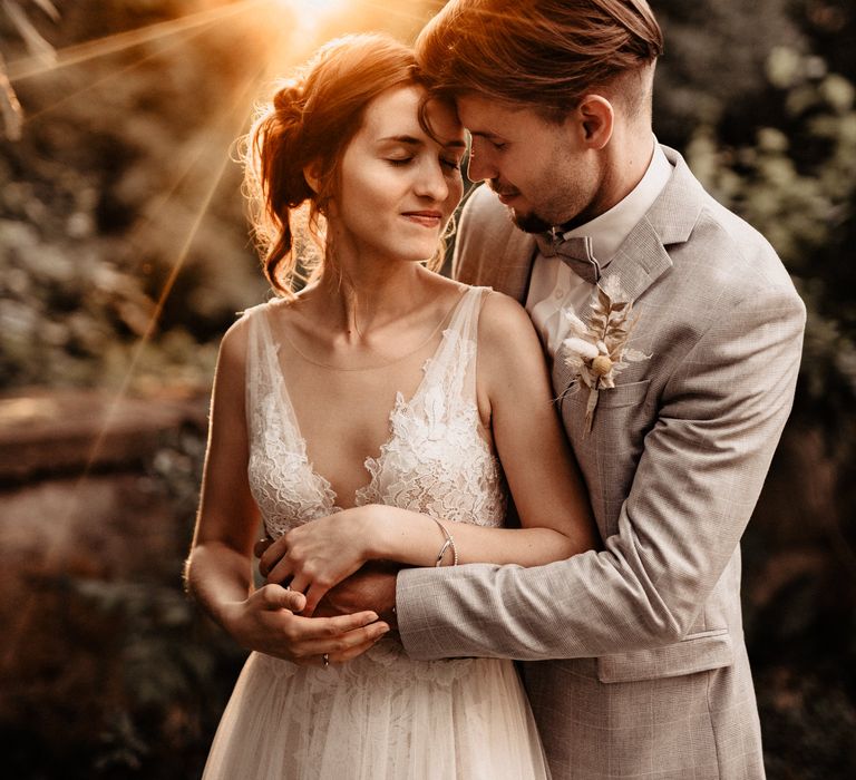 Bride in Watters dress with groom in castle gardens