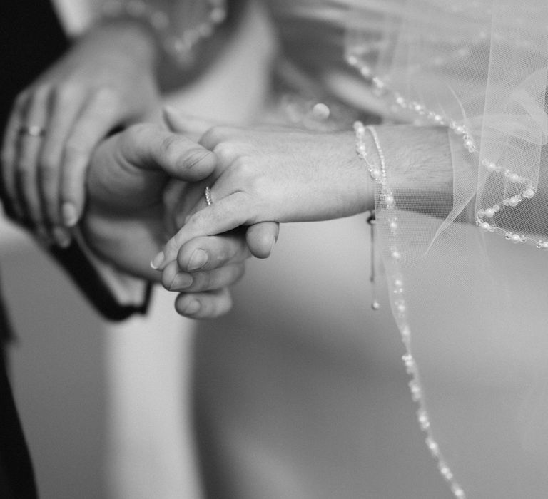 Bride & groom hold hands during wedding ceremony 