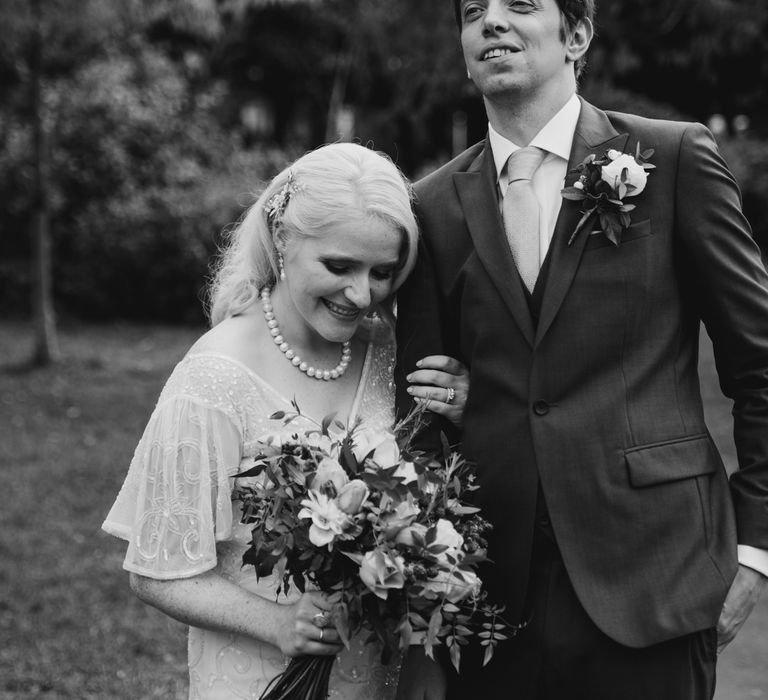 Bride & groom stand together in black & white image