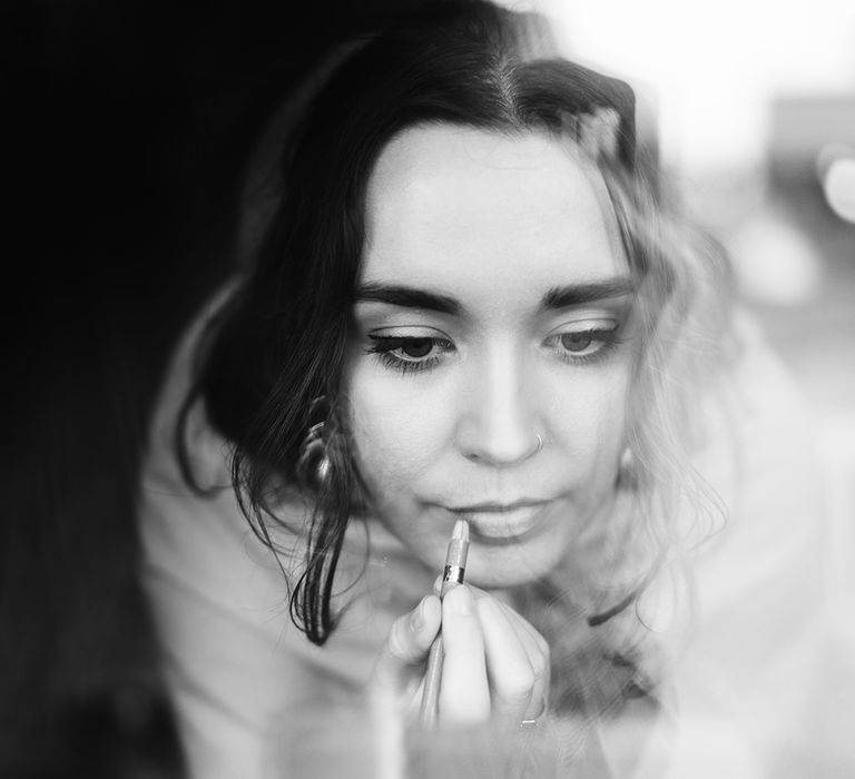 The bride applying her own makeup for her intimate destination wedding ceremony