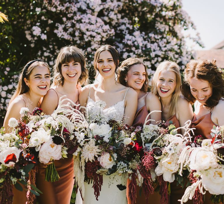 Bride stands with her bridesmaids who are wearing Topshop bridesmaids dresses