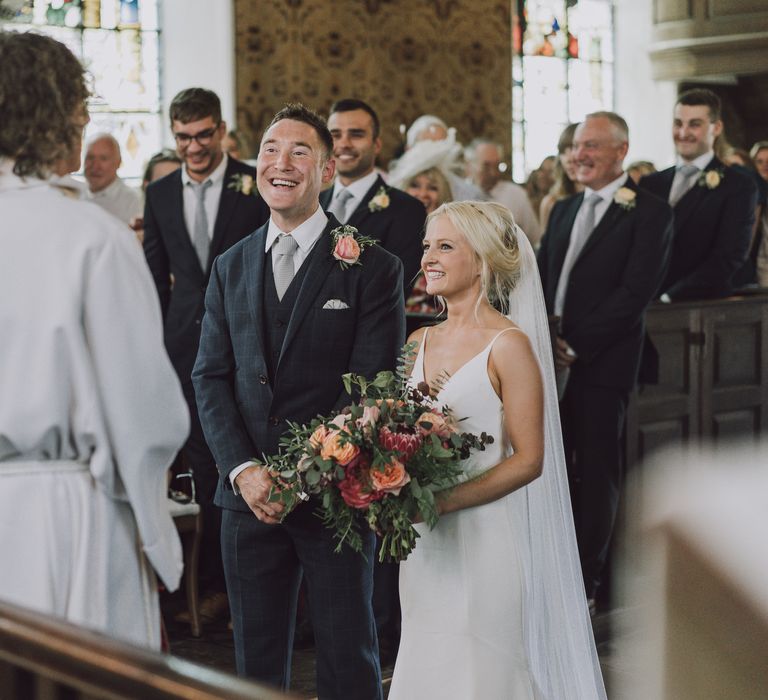 Bride & groom stand at the altar during church wedding ceremony