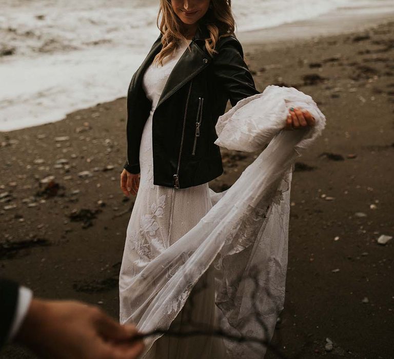 Bride in a fedora hat and leather jacket at seaside elopement 