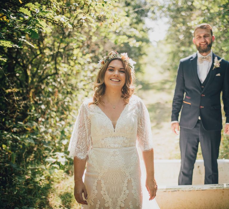 Groom stands in bathtub as bride laughs in front of him