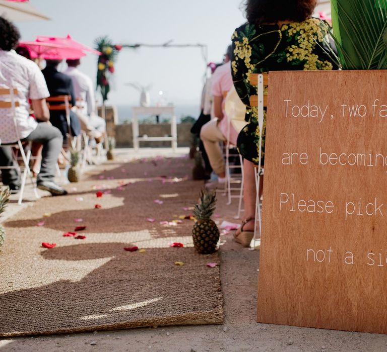 Wooden wedding ceremony sign at the end of the aisle