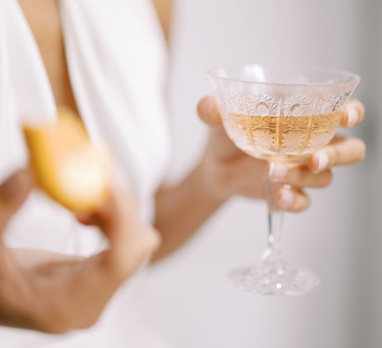 Bride holds champagne glass filled with champagne 