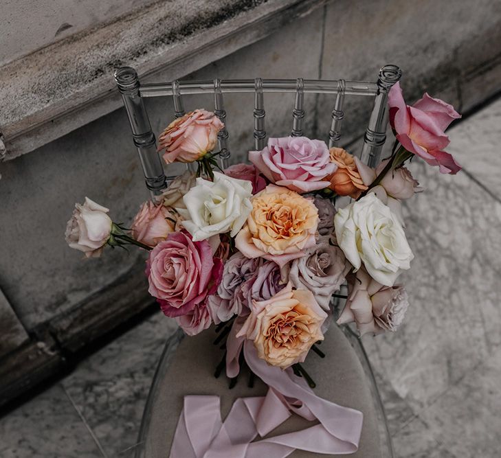 Blush pink, white and peach peeled back rose wedding bouquet tied with ribbon 