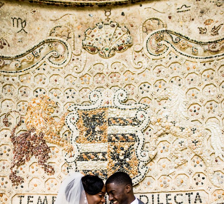 Black bride & groom sit together and look lovingly at one another