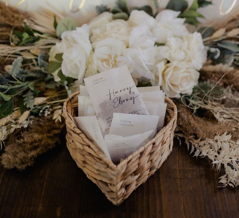 Personalised vellum confetti envelopes in a wicker basket 