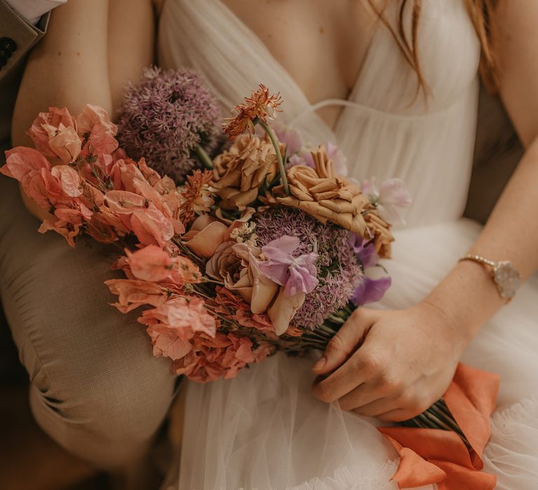 Pastel orange, pink and lilac wedding bouquet with alliums and roses 