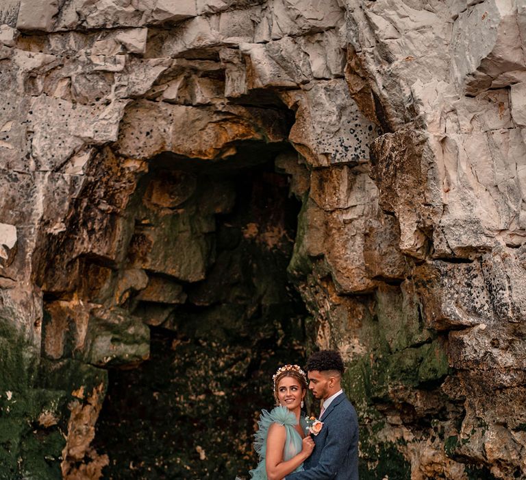 Botany Bay coastal wedding inspiration with bride in a mint green Millia of London frilly wedding dress and groom a blue wool suit 