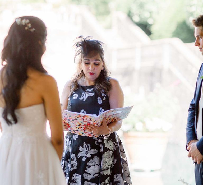 Celebrant during ceremony as bride & groom stand beside one another on their wedding day