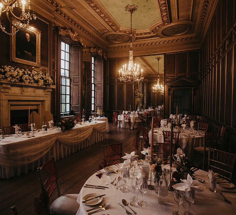 Gosfield Hall wedding reception complete with red ribbon tied around chairs and white tablecloths 