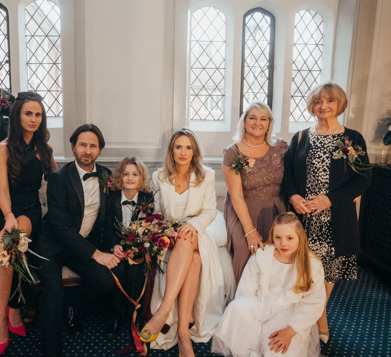 Bride & groom sit with their son and wedding guests at Gosfield Hall on their wedding day