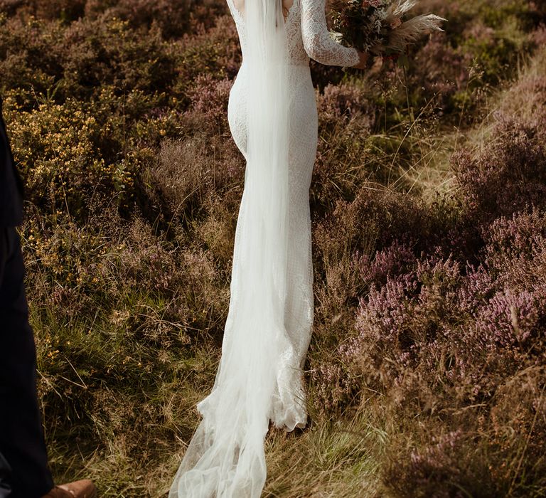 Bride in lace Maggie Sottero dress with long veil and autumnal bouquet and autumnal flower hair accessory 