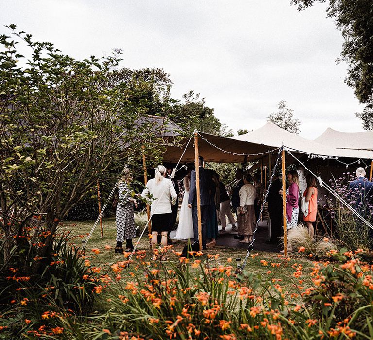 Wedding guests gather under canopy for outdoor wedding at Treseren wedding venue