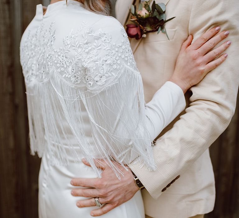 Satin wedding dress with long sleeves and embroidered and fringe design 