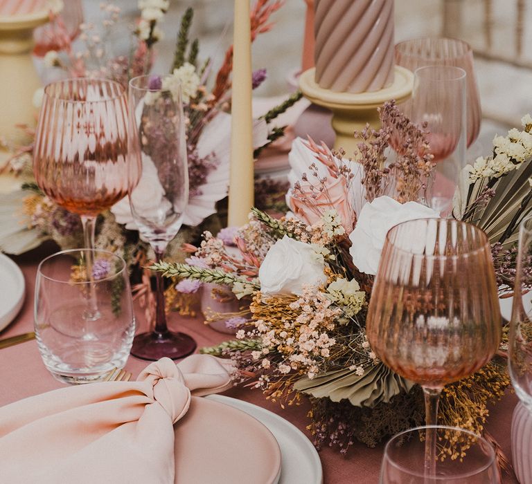 wedding table decor and preserved pastel flowers centrepiece with palm leaves, coloured goblets, church candles and more 