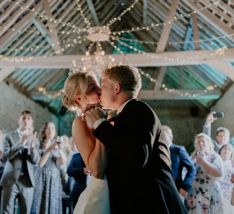 Bride and groom share their first dance and kiss 