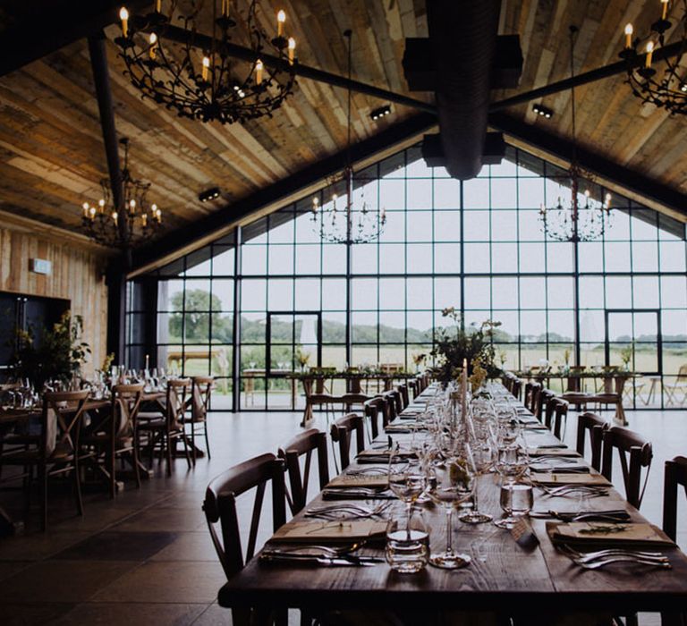 The Barn at Botley Hill wedding venue reception room with chandeliers and banquet tables 