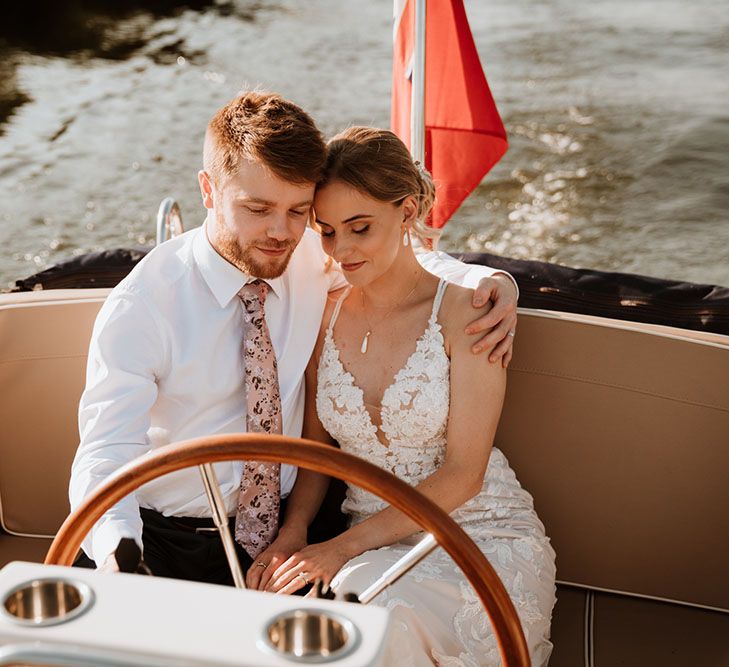 Bride & groom during boat ride across the Thames on their wedding day after outdoor wedding ceremony 