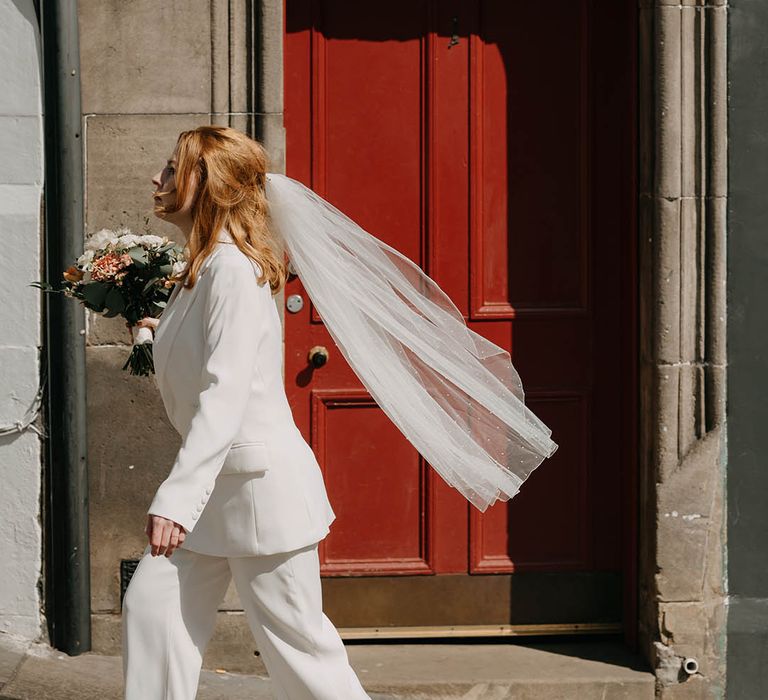 City Chambers Edinburgh wedding with bride in a trouser and jacket suit with finger tip veil 