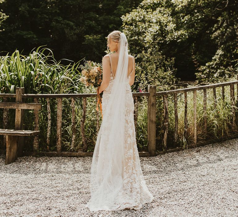 Bride wearing a floor length veil and Made With Love lace wedding dress 