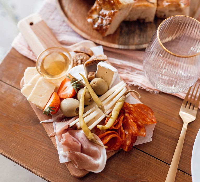 Charcuterie board for the wedding food with fluted glassware with gold rims 