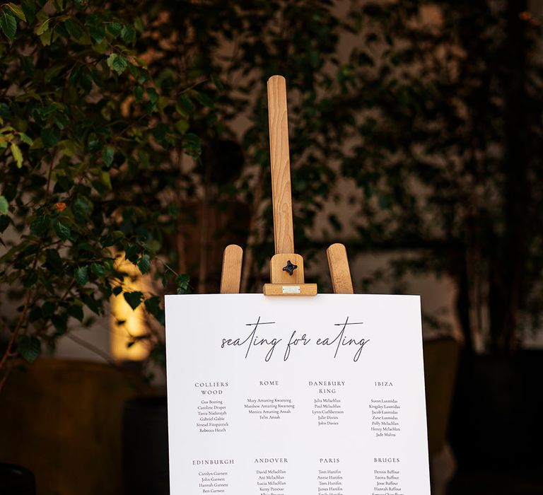 White seating chart in contemporary style on wooden easel 